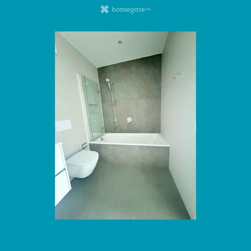 Bathroom. Modern bathroom with a glass shower enclosure, a bathtub, and a toilet. The walls and floor are tiled in a light gray color.