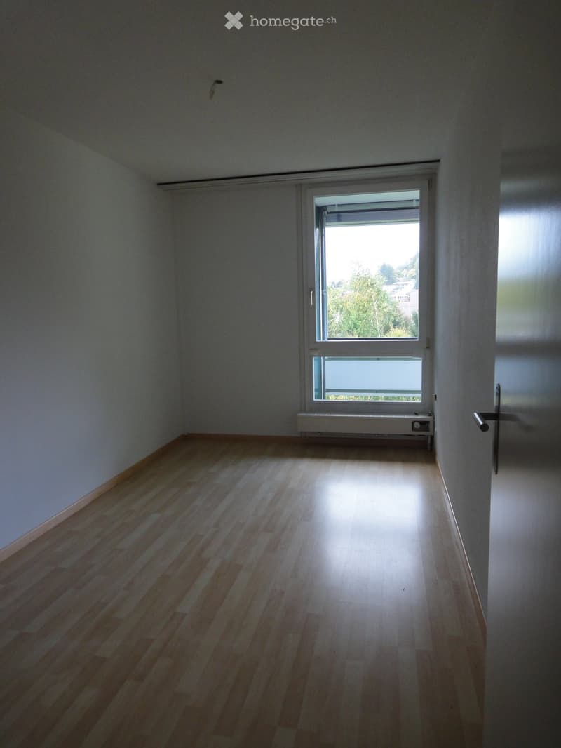 Unfurnished Room. Empty room with light wooden flooring and white walls, featuring a large window with blinds and a radiator below it.