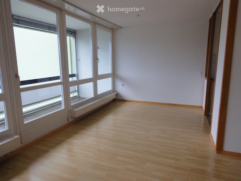 Unfurnished Room. Empty room with light wooden flooring, large windows, and white walls.