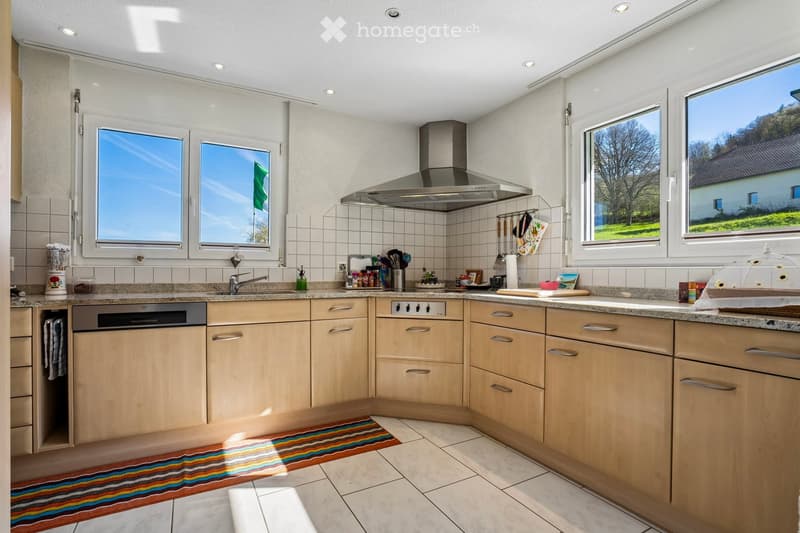 Modern kitchen with wooden cabinets, granite countertops, and stainless steel appliances.