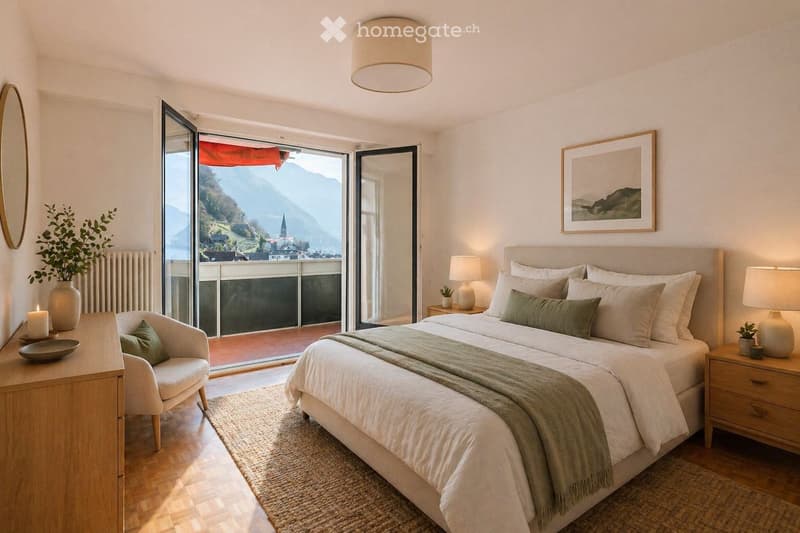 Modern bedroom with a large bed, nightstands, a chair, and a scenic view of mountains through large windows.