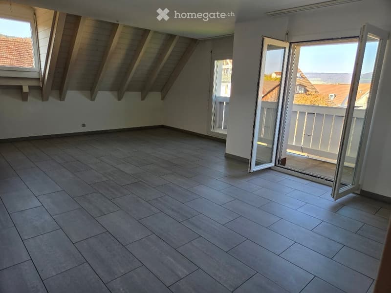 empty room with tiled flooring, two windows, double sliding glass doors leading to balcony