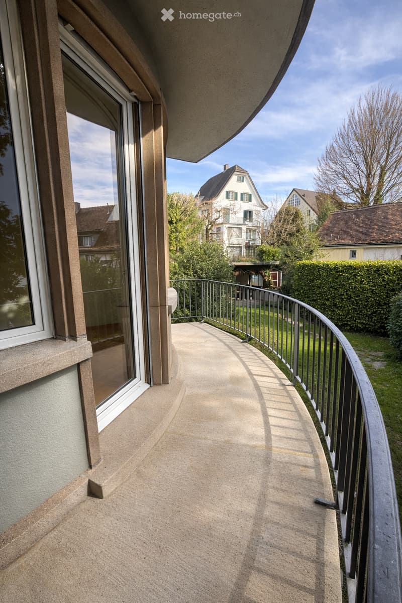Balcony with glass door, metal railing, concrete floor, view of the garden
