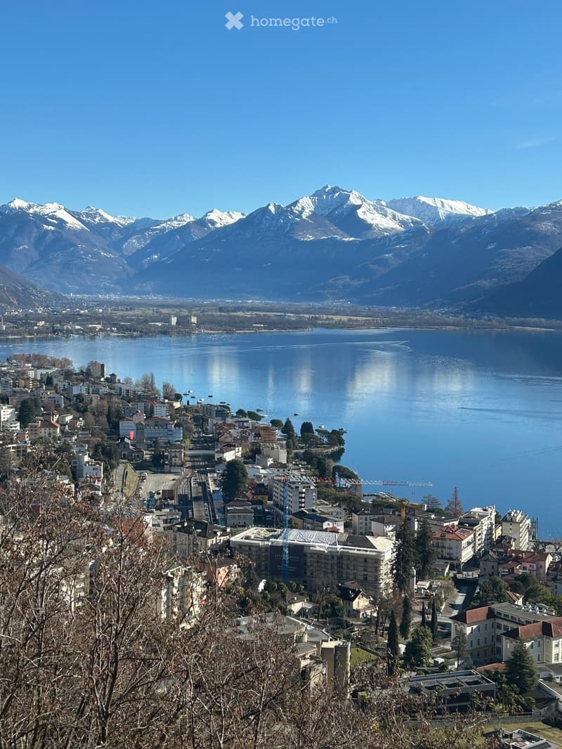 Lake Lugano, mountains, town, buildings, snow-capped peaks, distant city, clear sky