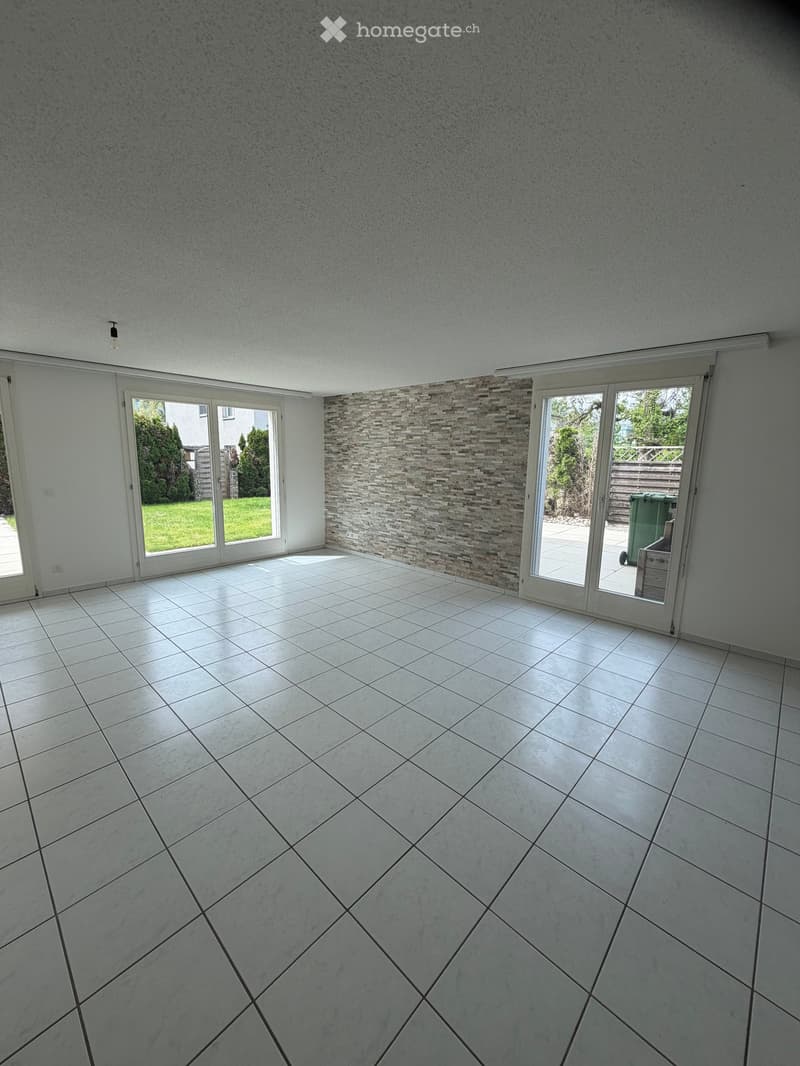 Unfurnished Room. Empty room with white tiled floor, large sliding glass doors, and a decorative tiled accent wall.