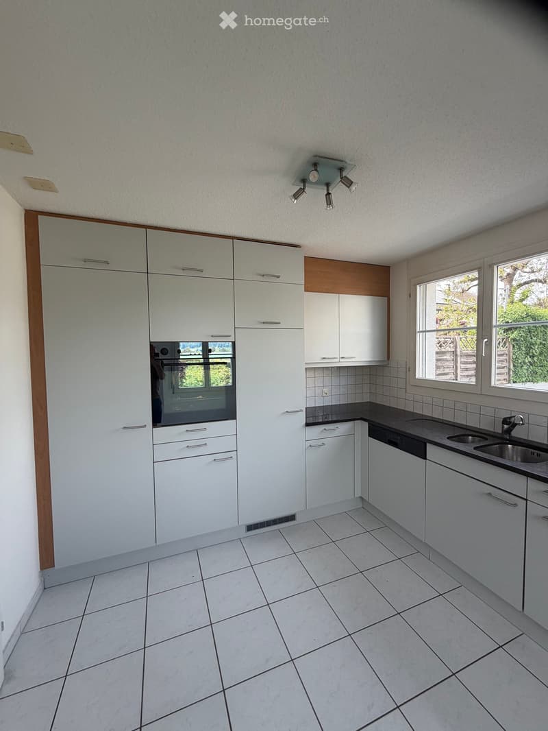 Kitchen. Modern kitchen with white cabinets, tiled floor, and stainless steel sink.