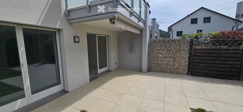 Garden / Outdoor Area. Balcony area with tiled floor, glass sliding doors, stone wall, wooden fence, and a view of neighboring houses.