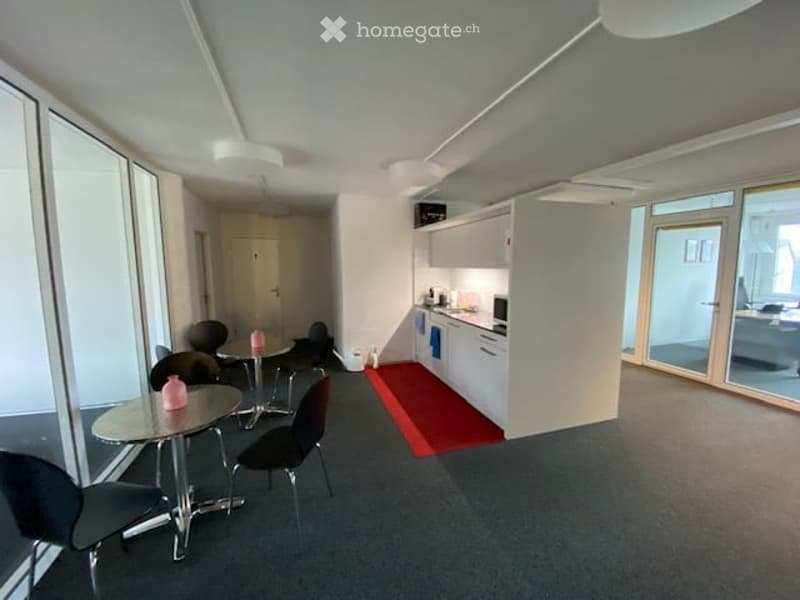 modern office room with glass walls, tables, chairs, kitchen, cabinets, sink, microwave, refrigerator