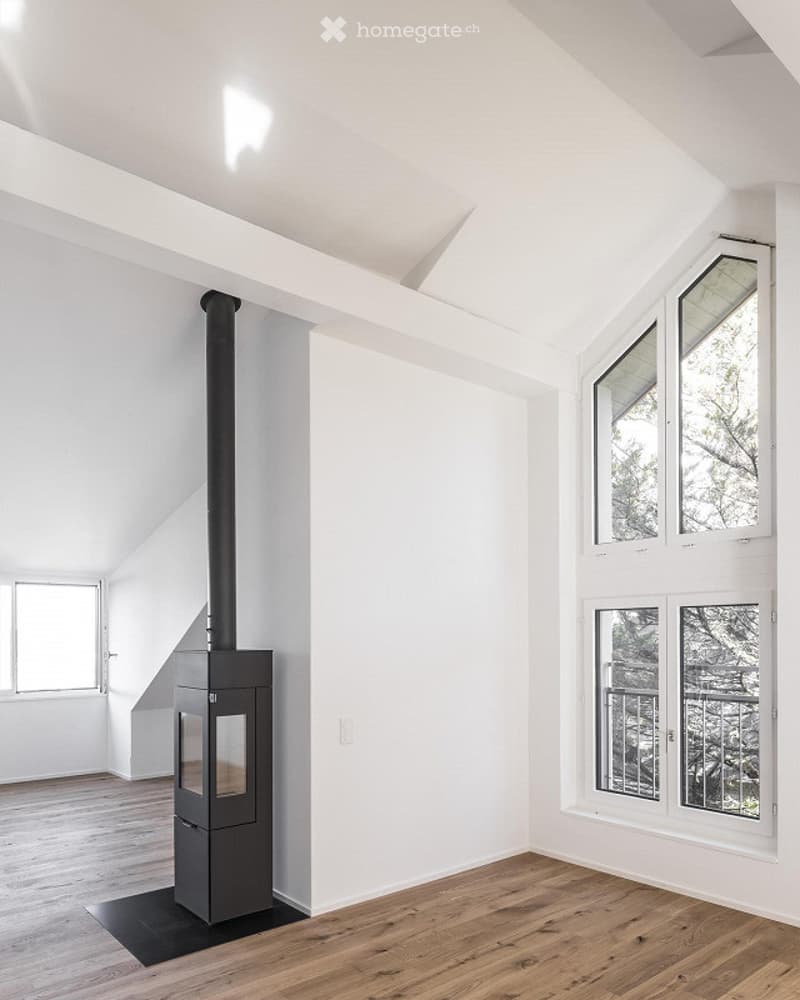 wooden floor, white walls, wood burning fireplace, windows with views