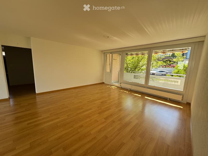 Unfurnished Room. Empty room with wooden floors, white walls, and large windows leading to a balcony. No furniture or decorations.