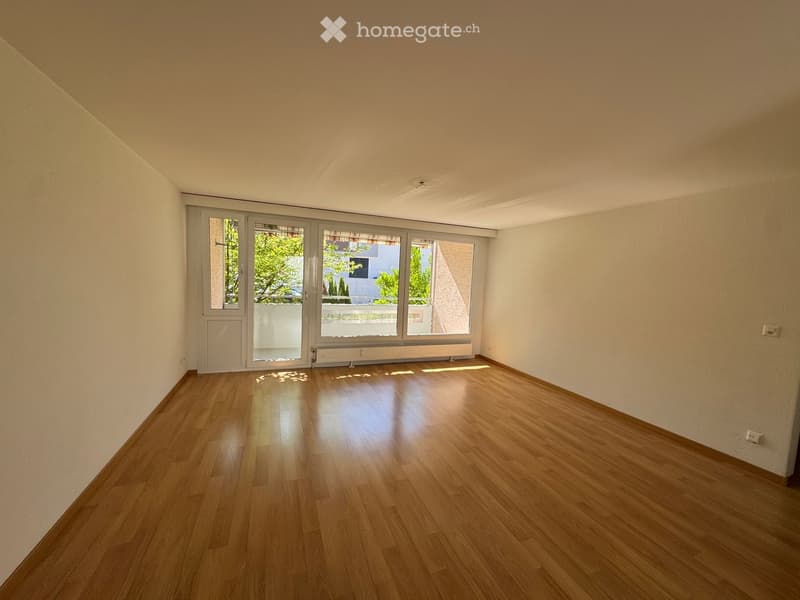 Unfurnished Room. Empty room with white walls, wooden floor, and large glass doors leading to a balcony.