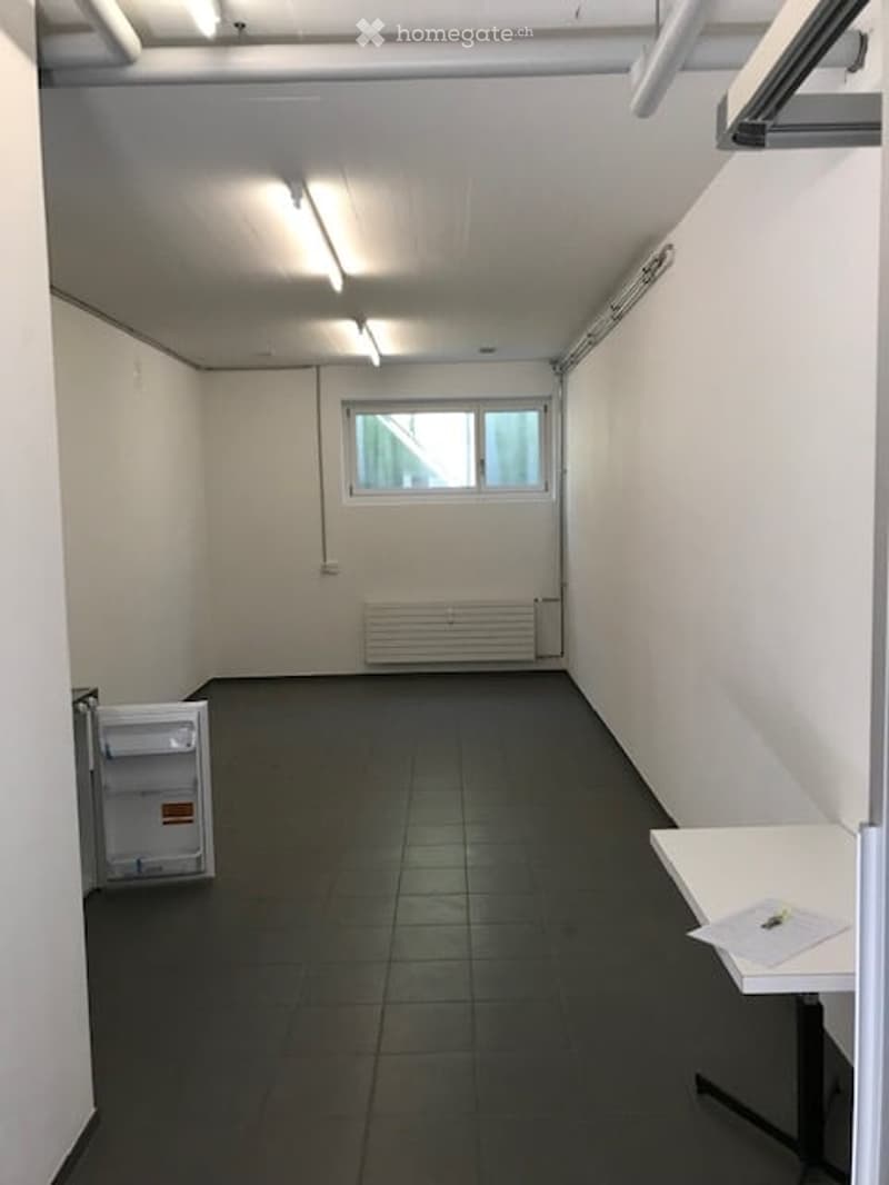 Empty room with white walls, black tiled floor, open refrigerator, white table, window, radiator