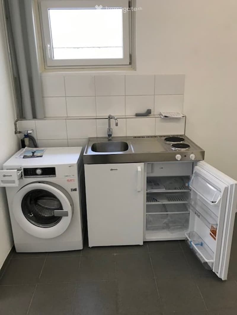 small kitchen with sink, stove, refrigerator, washing machine