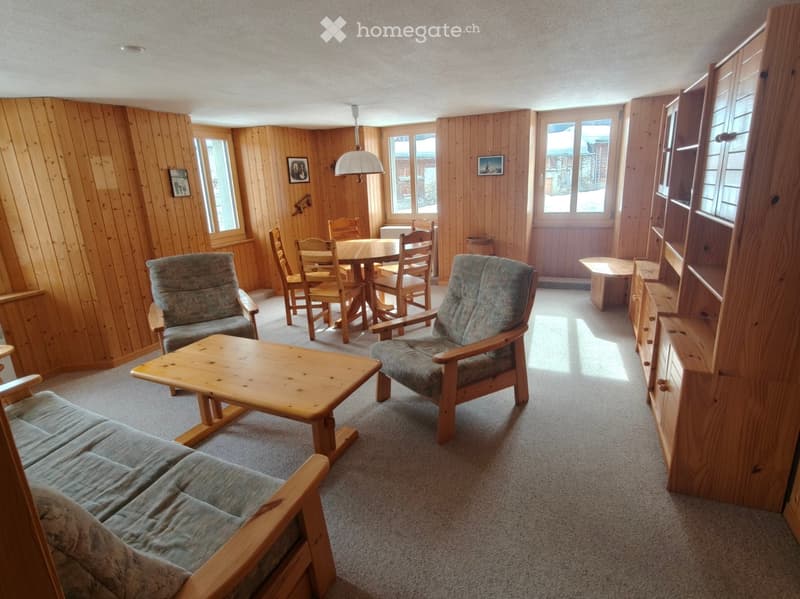 living room with wooden dining table and chairs, wooden couch, wooden shelves, wooden cabinets, wooden floor, and wooden lamp