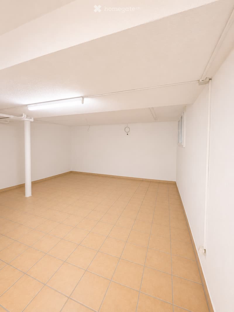 Empty room with tiled floor and white walls, featuring a single window and a white column.