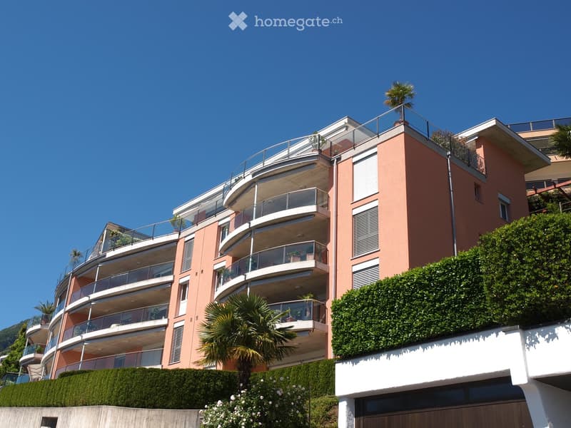 Apartment building, balcony on each floor, greenery, multiple floors, south facing
