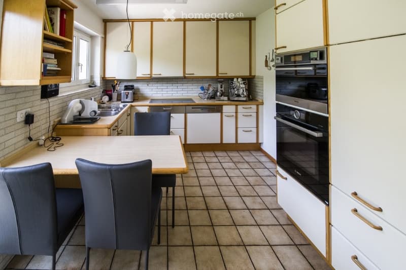 kitchen with a table, chairs, tiled floor, white cabinets, dishwasher, double oven, granite countertop