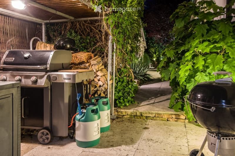 Outdoor grill area, wooden canopy, two gas tanks, wooden storage area, wooden walkway