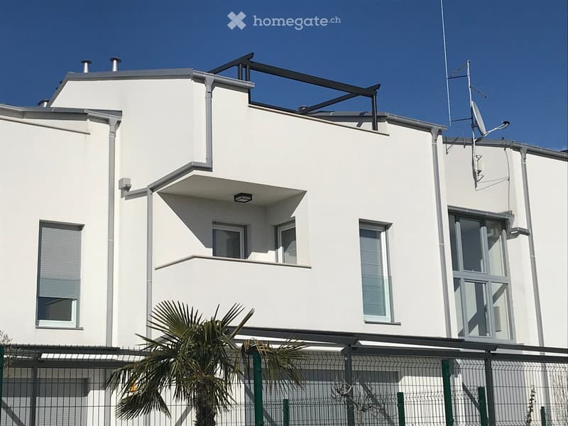 Building. Modern two-story white building with large windows, satellite dish, and a small balcony on the upper floor.