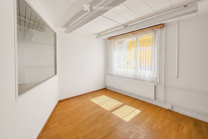 Unfurnished Room. Empty room with wooden flooring, white walls, large windows, and a radiator. No furniture or equipment present.