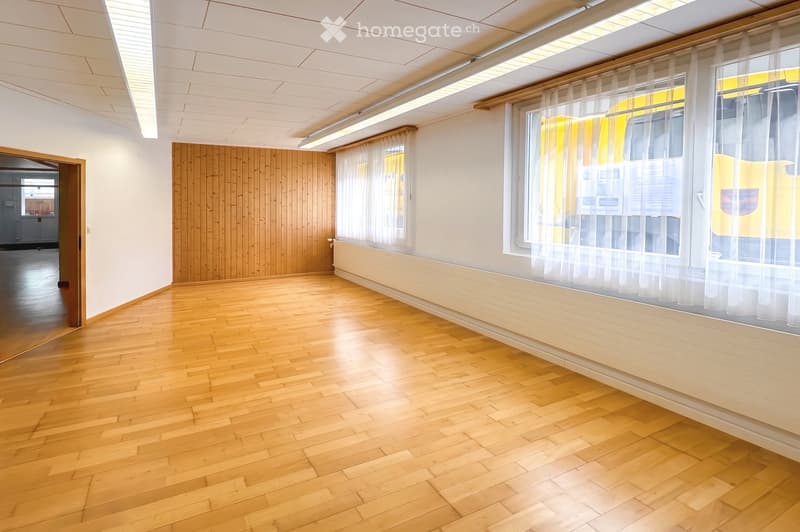 Unfurnished Room. Empty room with wooden flooring, white walls, large windows with sheer curtains, and a wooden panel accent wall.