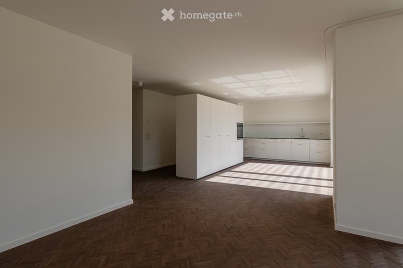 empty kitchen with modern white cabinets and wooden floors