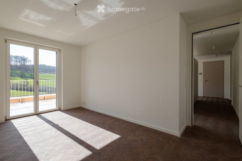 large sliding glass door leading to balcony, parquet flooring, white walls, view of a field outside
