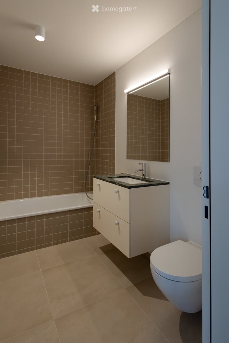 Bathroom with white walls, tile flooring, bathtub, sink, white toilet, mirror, recessed lighting