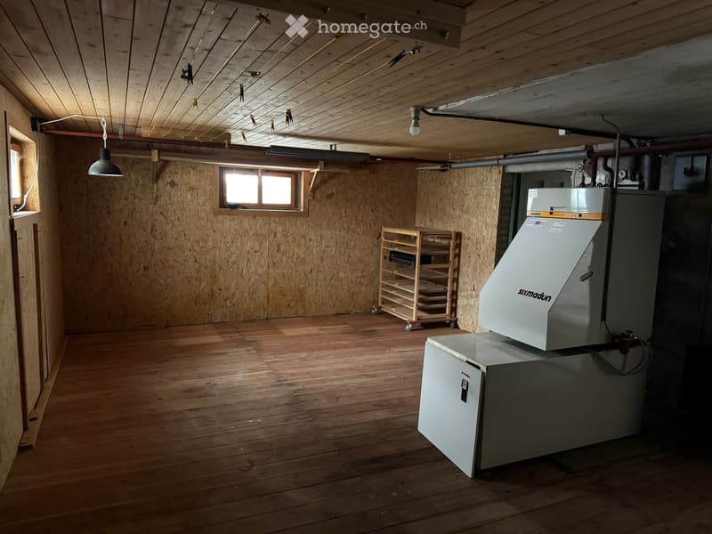 Unfurnished Room. Empty basement room with wooden walls and ceiling, wooden floor, single window, and a small shelving unit. No furniture or equipment.