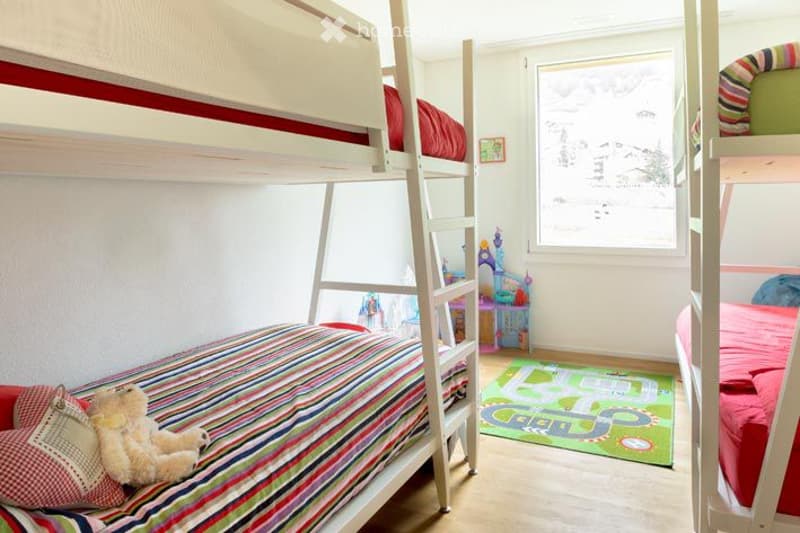 Bedroom. Bright bedroom with bunk beds, colorful bedding, a teddy bear, and a play rug.