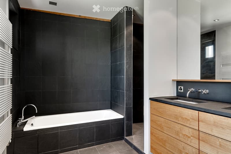 Bathroom. Bathtub, wall and floor tiles, dual sinks, wooden vanity, under-sink cabinet, shower enclosure, wall radiator