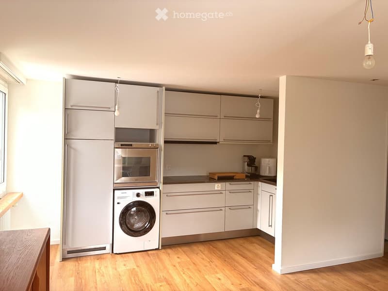 modern kitchen with white cabinets, wooden floor, washing machine, microwave, refrigerator, countertop, coffee machine, kettle, toaster, and a window
