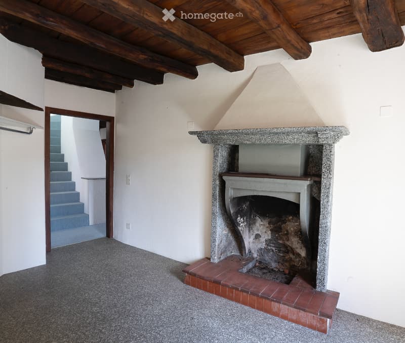 Corridor / Hallway. A view looking down a staircase with a wooden railing and a fireplace in the background.