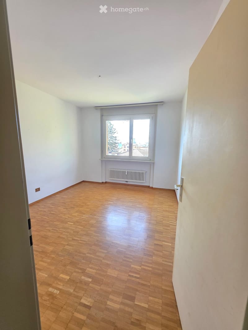 empty room, wooden floor, white walls, window with view, white radiator