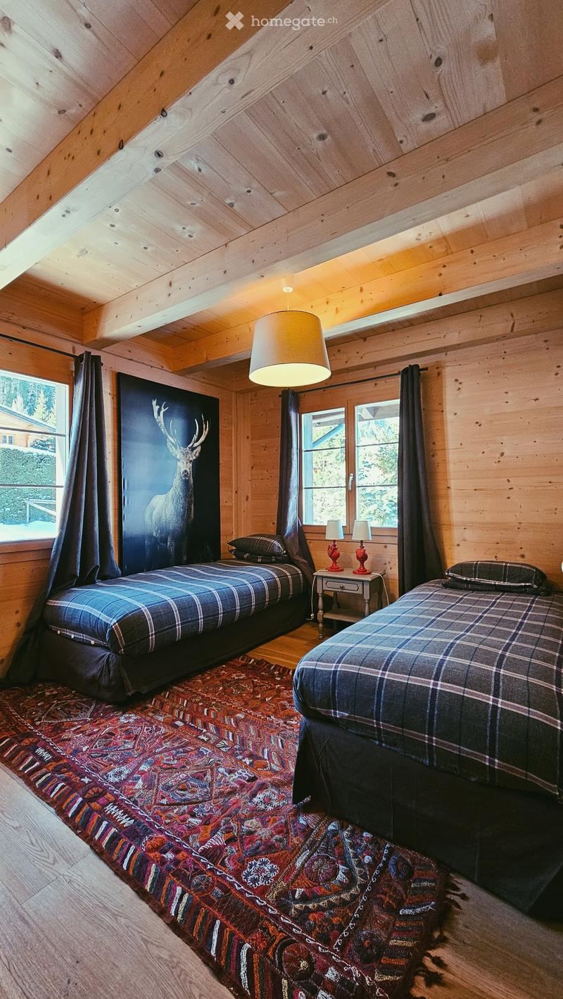 two beds, rug, wooden walls, window, picture of deer, lamps