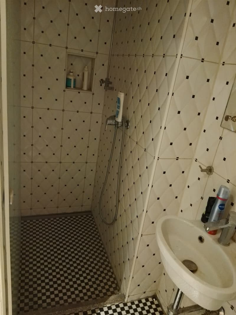 small bathroom with shower, sink, and tiled floor