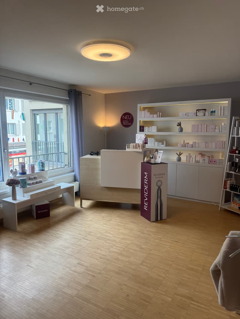 large open space, reception desk, open shelves, large window, wooden floor, lighting fixture