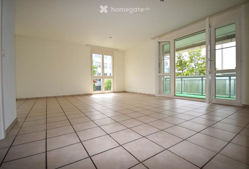 Unfurnished Room. Empty room with tiled floor, white walls, and large windows with sliding doors leading to a balcony area.