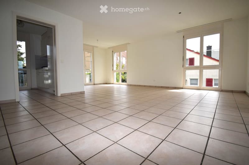 Unfurnished Room. Empty room with tiled floor and white walls, featuring large windows and an open doorway leading to another room.
