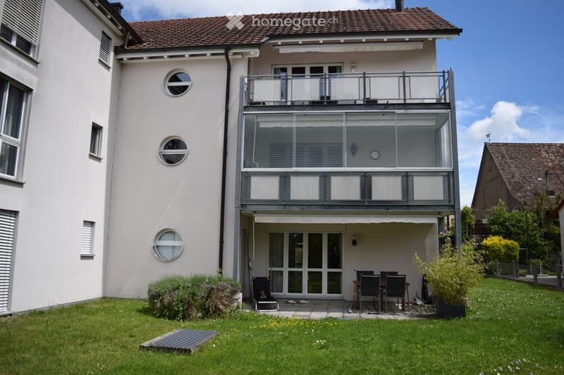 House. Two-story house with a balcony, patio area, and well-maintained garden.