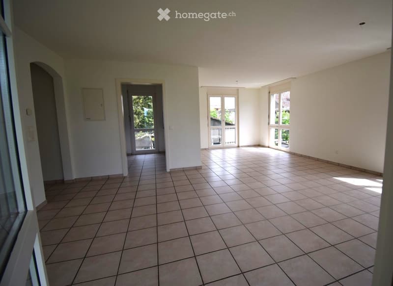 Unfurnished Room. Empty room with tiled flooring and white walls, featuring multiple windows and a door leading to another space.