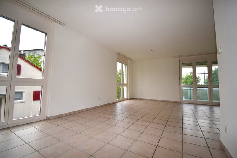 Unfurnished Room. Empty room with tiled floor, white walls, large windows, and sliding glass doors leading to an outdoor area.