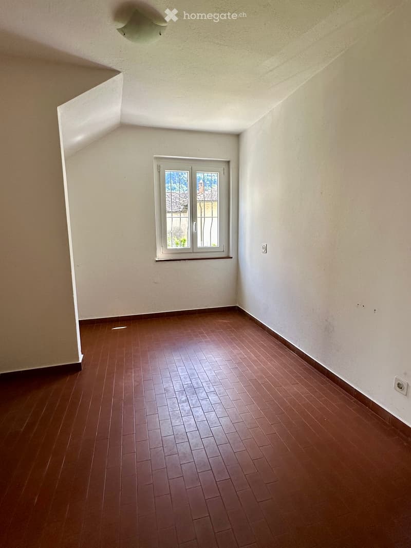 Unfurnished Room. Empty room with wooden flooring and white walls, featuring a single window with white frame and glass panels.