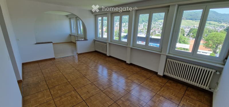 Unfurnished Room. Empty room with wooden flooring, large windows offering a scenic view, and radiators along the walls.
