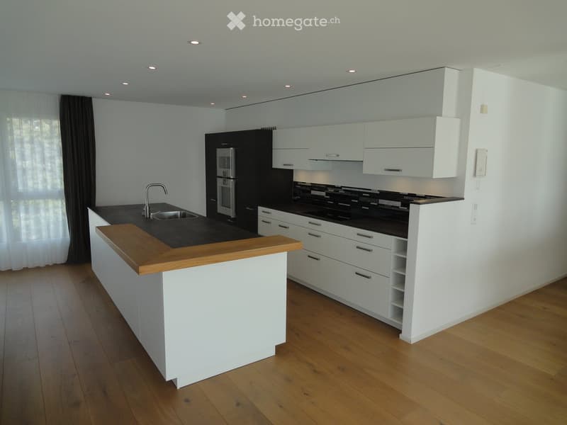 Kitchen. Modern kitchen with white cabinets, black countertops, a wooden island, and stainless steel appliances.
