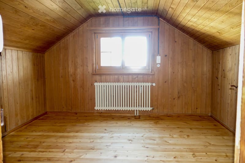 Unfurnished Room. Empty room with wooden walls, wooden floor, and a single window with a radiator below it.