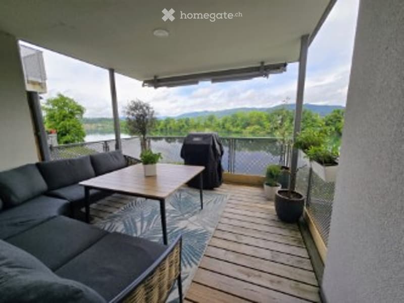 Balcony / Terrace. Balcony with wooden decking, outdoor furniture including a sofa, coffee table, and potted plants, overlooking a scenic mountain view.