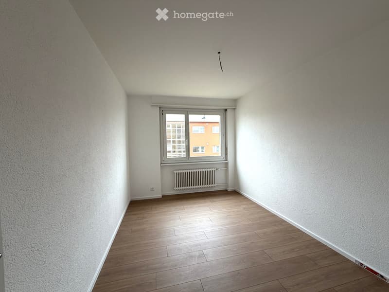 Unfurnished Room. Empty room with wooden flooring, white walls, a window with blinds, and a radiator below the window.