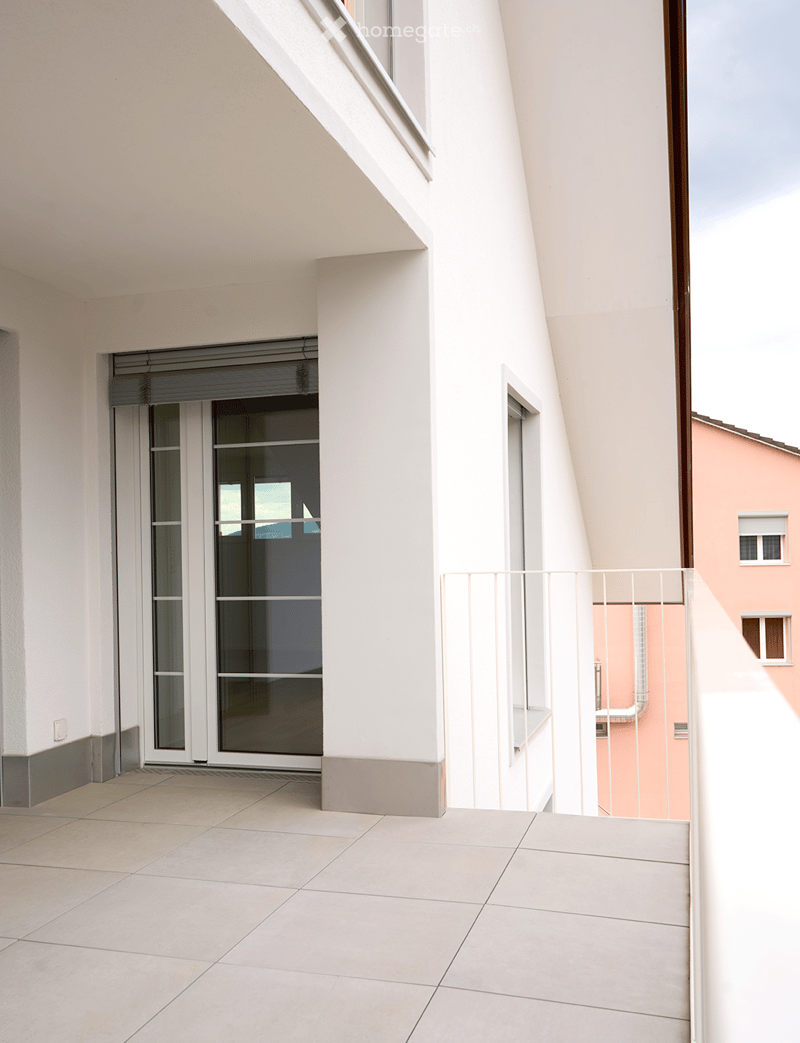 Balcony / Terrace. Balcony with tiled floor, white railing, sliding glass door leading inside, view of neighboring building.