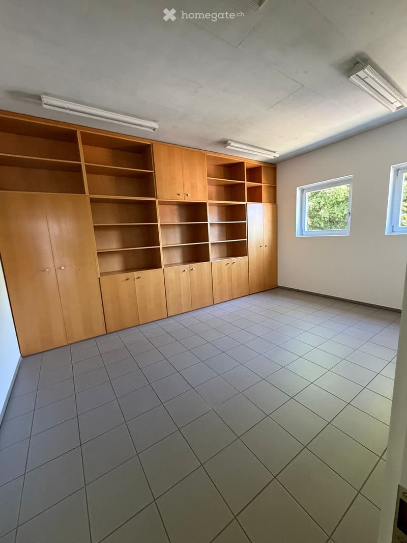 Unfurnished Room. Empty room with tiled floor, wooden built-in shelving unit, and two windows letting in natural light.